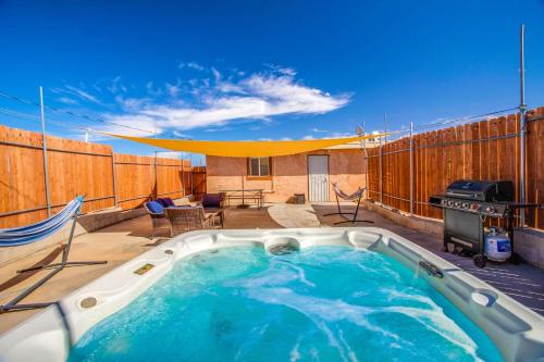 a hot tub on a patio with a grill at Cacti Sanctuary in Sunfair Heights