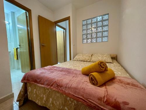 um quarto com uma cama com duas toalhas amarelas em Little Horse apartments 1 em Tarragona
