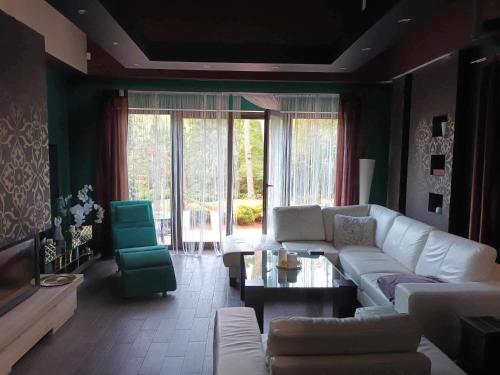 a living room with a white couch and a table at Dom całoroczny na wynajem - Zalesie nad jeziorem Chełmżyńskim koło Torunia 