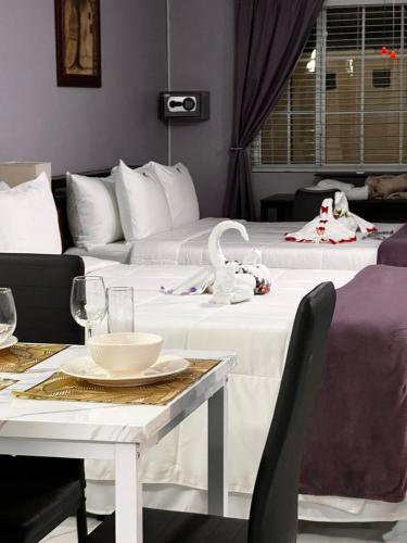 a hotel room with two beds and a table and chairs at Lavender Moon Villas in Breadnut Hill