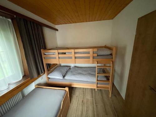 two bunk beds in a small room with a window at Pension Balm in Meiringen