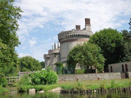 an old castle sitting on the side of a river at Studio Vue Loir, Centre-Ville in Bonneval