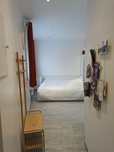 a room with a bed and a refrigerator and a chair at Studio Vue Loir, Centre-Ville in Bonneval