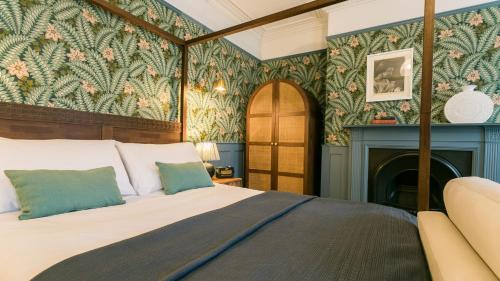 1 dormitorio con 1 cama y chimenea en The Papered House, en Beaumaris