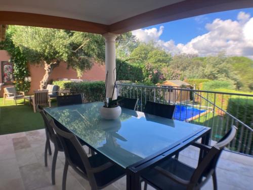 - une table et des chaises sur une terrasse avec vue sur la piscine dans l'établissement MAGNIFICENT VILLA AND ITS PRIVATE SALT POOL CLASSIFIED 4* BY THE TOURIST OFFICE, à Sainte-Maxime