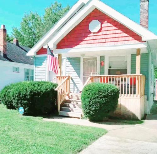 a small house with a porch and an american flag at *All-American Home Minutes From Case/UH/Cle Clinic in Cleveland Heights