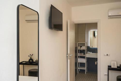 a bathroom with a mirror and a television on a wall at infinity Castellabate b & b di Charme in Santa Maria di Castellabate