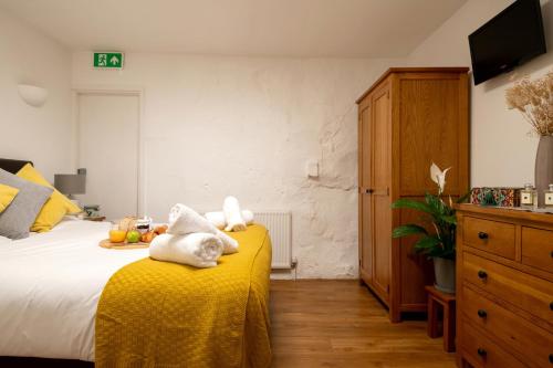 a bedroom with a bed with a yellow blanket at Bulverton House Holiday Cottages in Sidmouth