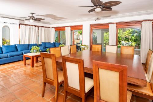 a dining room with a table and a blue couch at Villa tropically in Hotel Zone in Cancún