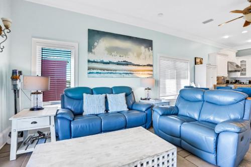 a living room with blue chairs and a table at Bird's Eye View in St. George Island