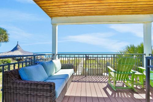 a patio with a couch and a chair on a deck at Bird's Eye View in St. George Island