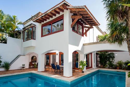 a villa with a swimming pool and a house at Villa tropically in Hotel Zone in Cancún