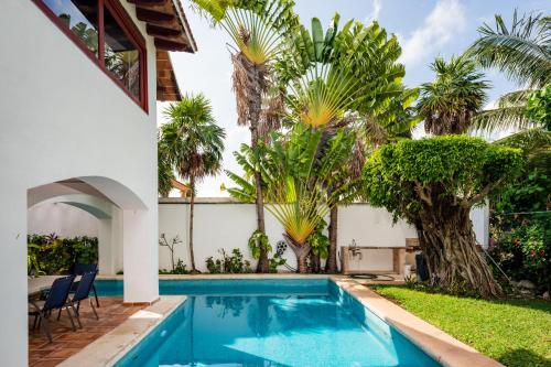 a swimming pool in the backyard of a house with palm trees at Villa tropically in Hotel Zone in Cancún
