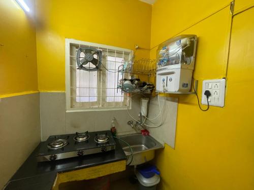 Una pequeña cocina con fregadero y ventana. en HOME STAY in ground floor, en Chennai