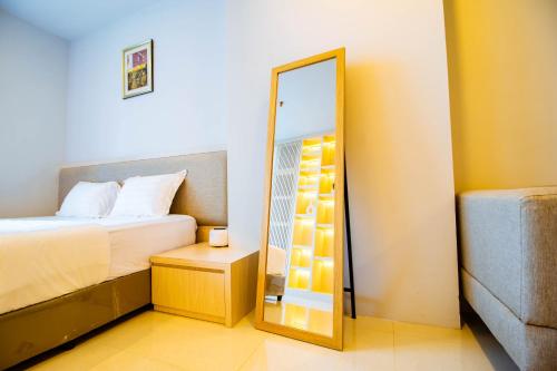 a bedroom with a mirror next to a bed at Formosa Spacious Apartments with Netflix & Pick Up Service by MESA in Nagoya
