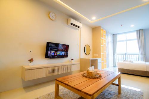 a living room with a table and a tv on the wall at Formosa Spacious Apartments with Netflix & Pick Up Service by MESA in Nagoya