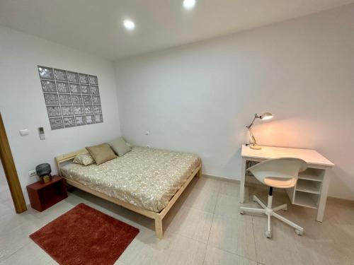 a bedroom with a bed and a desk and a table and chair at Little Horse apartments 3 in Tarragona