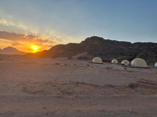 a group of tents in the desert at sunset at Nara Wadi RUM Camp in Wadi Rum