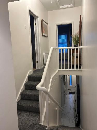 a staircase in a home with a white stair case at The White House in Newry