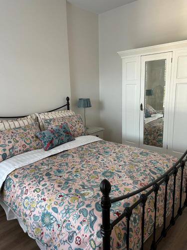 a bedroom with a bed with a floral bedspread at The White House in Newry
