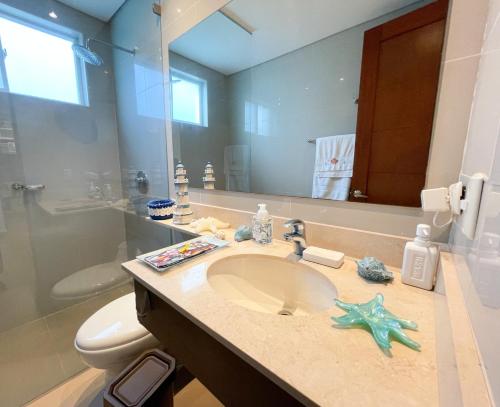 y baño con lavabo, aseo y espejo. en Casa de Playa, en Cartagena de Indias