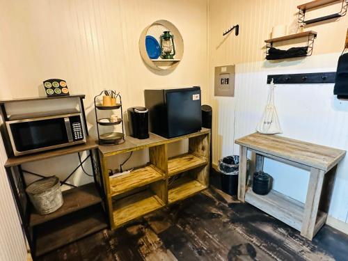 a living room with a microwave and a table at Acorn Hideaways Canton Gold Panner Bunkhouse King Bed in Canton