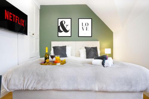 een slaapkamer met een groot wit bed en een groene muur bij Central Buckingham Apartment #9 with Free Parking, Pool Table, Fast Wifi and Smart TV with Netflix by Yoko Property in Buckingham