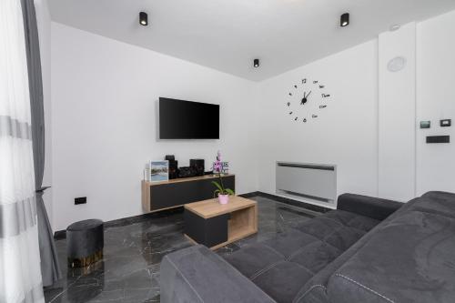 a living room with a couch and a tv at Villa Alison Deluxe Junior with private spa and heated swimming pool in Nedeščina