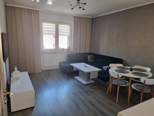 een woonkamer met een bank en een tafel en stoelen bij Apartament Pyskowice Centrum in Pyskowice