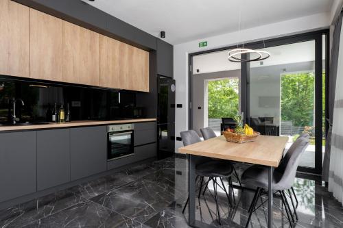 a kitchen with a wooden table and chairs at Villa Alison Deluxe Junior with private spa and heated swimming pool in Nedeščina