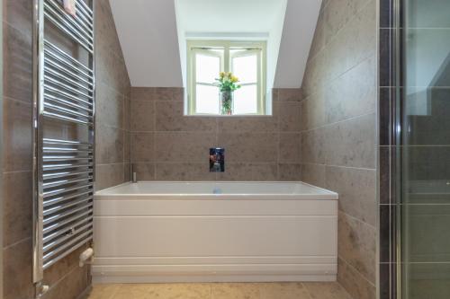 a bathroom with a bath tub and a window at The Woodstock Hideaway - Breathtaking 4BDR House in Woodstock