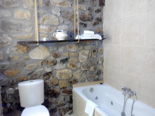 a stone bathroom with a toilet and a bath tub at Posada Montero de la Concha in Esles
