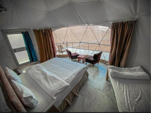 a bedroom with two beds and a window with a view at RUM EiLEEN LUXURY CAMP in Wadi Rum