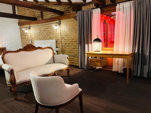 a bedroom with a chair and a table and a desk at Hotel Caney Villa de Leyva in Villa de Leyva