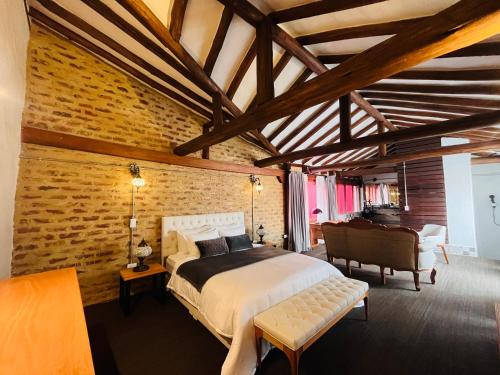 a bedroom with a bed and a brick wall at Hotel Caney Villa de Leyva by MH in Villa de Leyva