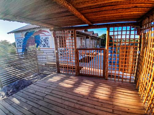a wooden deck with a gate on a playground at Pousada Vila Jasmim em Caraíva in Caraíva