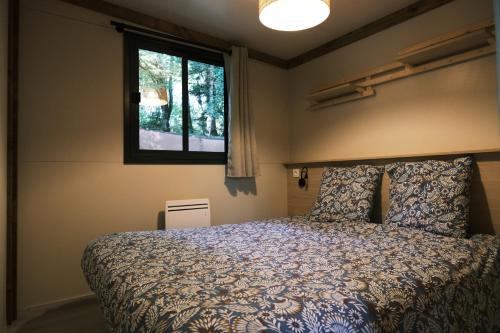 um quarto com uma cama e uma janela em Lodge avec SPA privatif - Foret et Lac em Liginiac