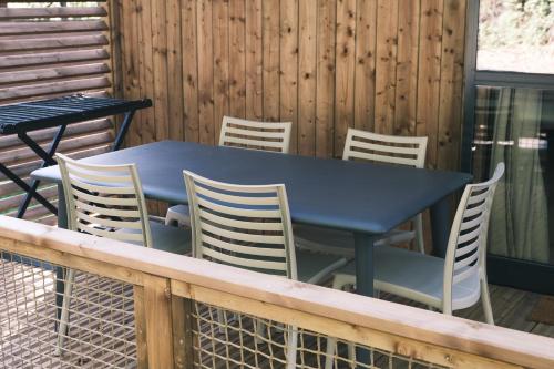 a blue table and chairs on a deck at Lodge avec SPA privatif - Foret et Lac in Liginiac