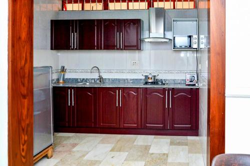 a kitchen with red cabinets and a sink at 2 Bedroom Bungalow in Alalubosa GRA in Ibadan