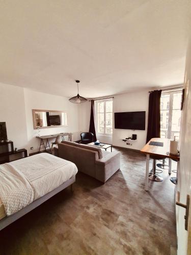 une chambre avec un lit, un canapé et une télévision dans l'établissement Studio de l'hôtel de ville, à Charleville-Mézières