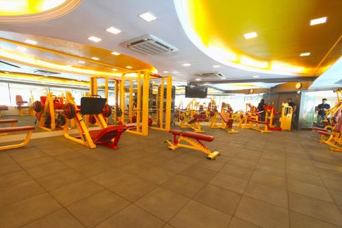 a gym with lots of tread machines and people in it at Home2 Renaissance Club in Mumbai
