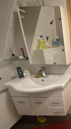 a white bathroom sink with a mirror above it at vasu Muthalagan in Aalen