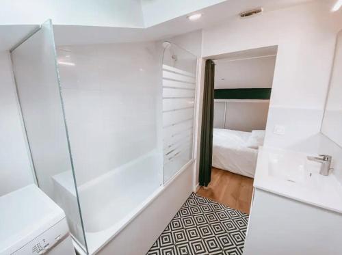 a bathroom with a shower and a sink and a bed at Libourne - CARNOT - Centre Ville in Libourne