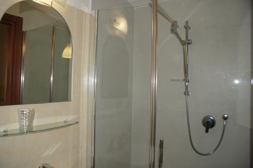 y baño con ducha y puerta de cristal. en Geoglobe Chambre d'Hòtes, en Pisa