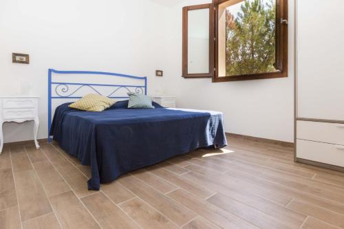 a bedroom with a blue bed and a mirror at Casa al Mare in Capoliveri