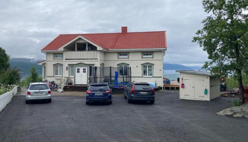 a house with three cars parked in a parking lot at New Aurora Hotspot - Studio Nordspissen in Tromsø