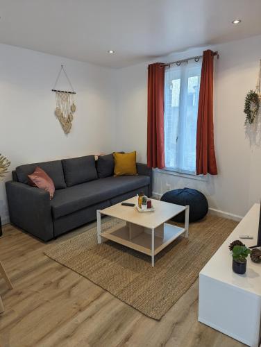 a living room with a couch and a table at Duplex de 65 m2, Cœur de Bonneval in Bonneval