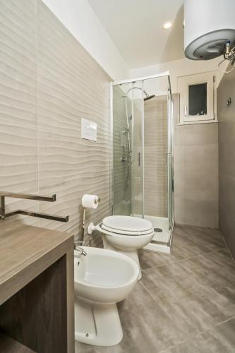 a bathroom with two toilets and a glass shower at infinity Castellabate b & b di Charme in Santa Maria di Castellabate