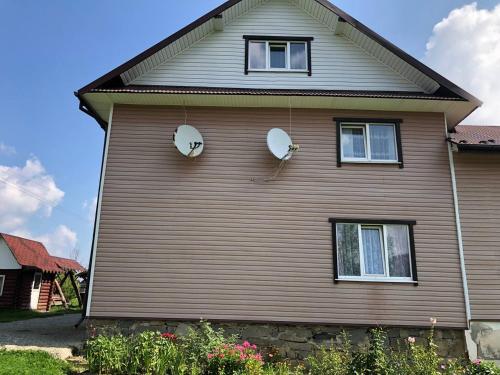 a house with two windows on the side of it at Котедж у Карпатах in Tukholʼka