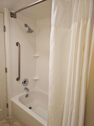 La salle de bains est pourvue d'une baignoire blanche avec rideau de douche. dans l'établissement Fairfield Inn & Suites by Marriott Charleston Airport/Convention Center, à Charleston